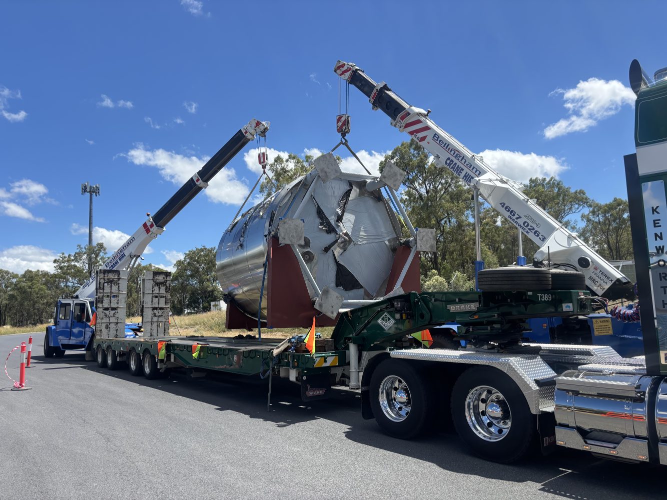 OOG cargo (large tank) being craned onto low-loader truck